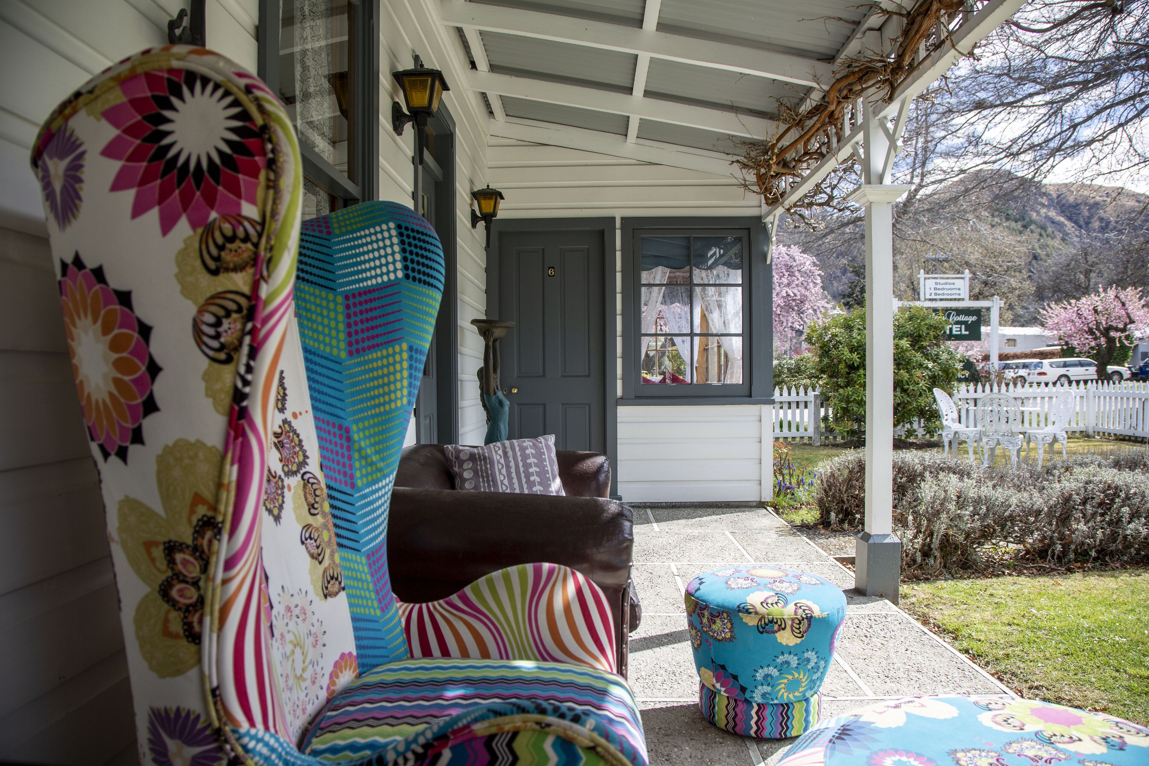 A porch with a covered seating area, a door with a number, and a view of a mountain.