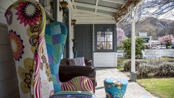 A porch with a covered seating area, a door with a number, and a view of a mountain.