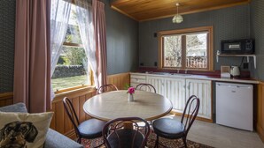 Una cocina acogedora con una mesa redonda, armarios de madera y un microondas integrado.