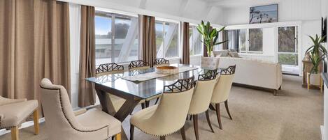 En matplats med ett glasbord, beige stolar och en vit soffa.