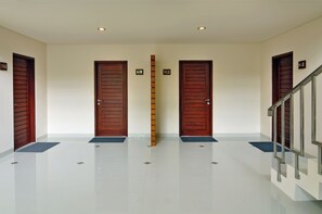 A hallway with three wooden doors, numbered 82, 83, and 84, leading to rooms.