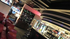A bar area with leather seating and a counter displaying various bottles. - The Astra Hotel (Broken Hill)