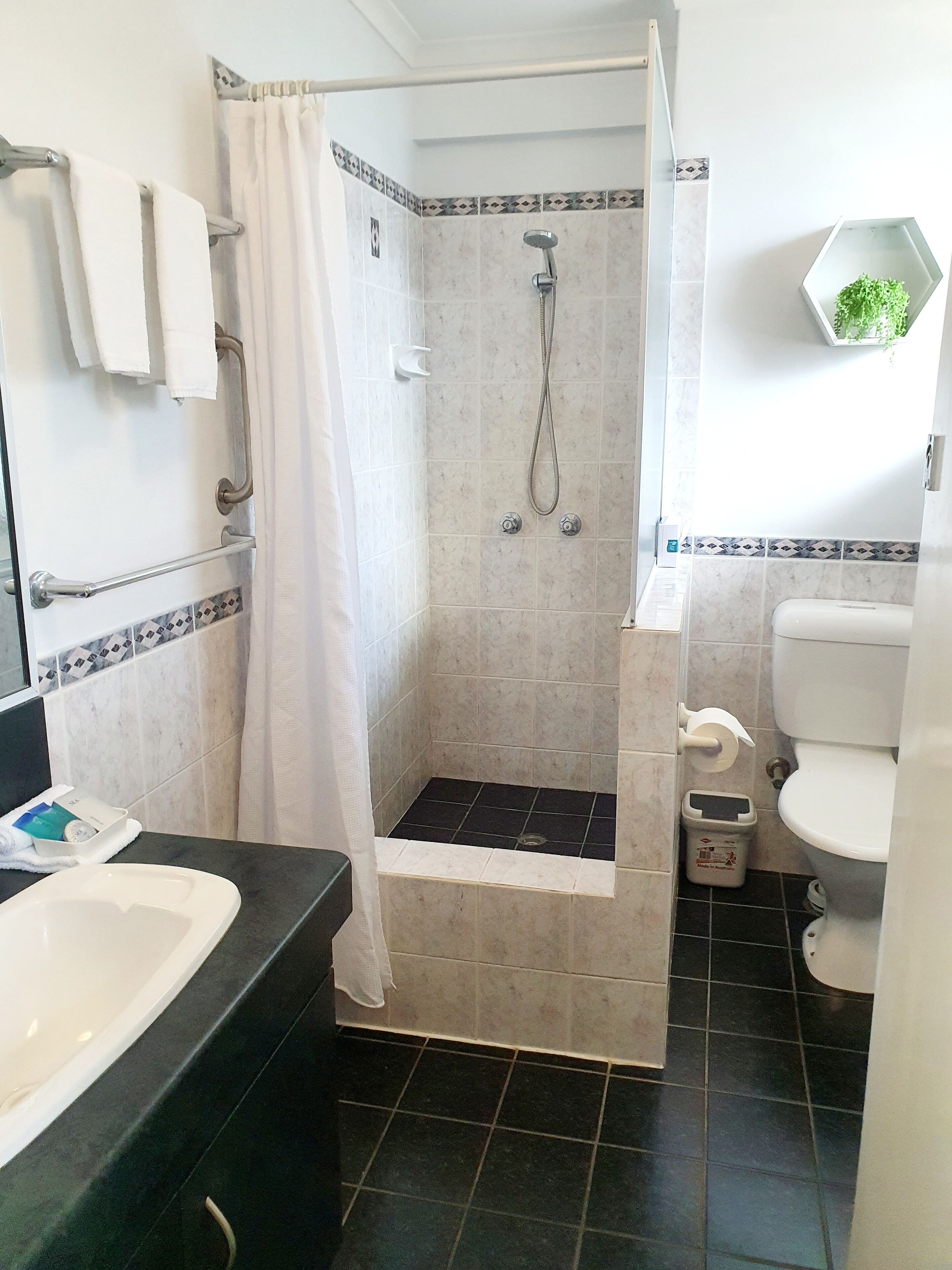Ein Badezimmer mit Dusche, Toilette und Waschbecken.