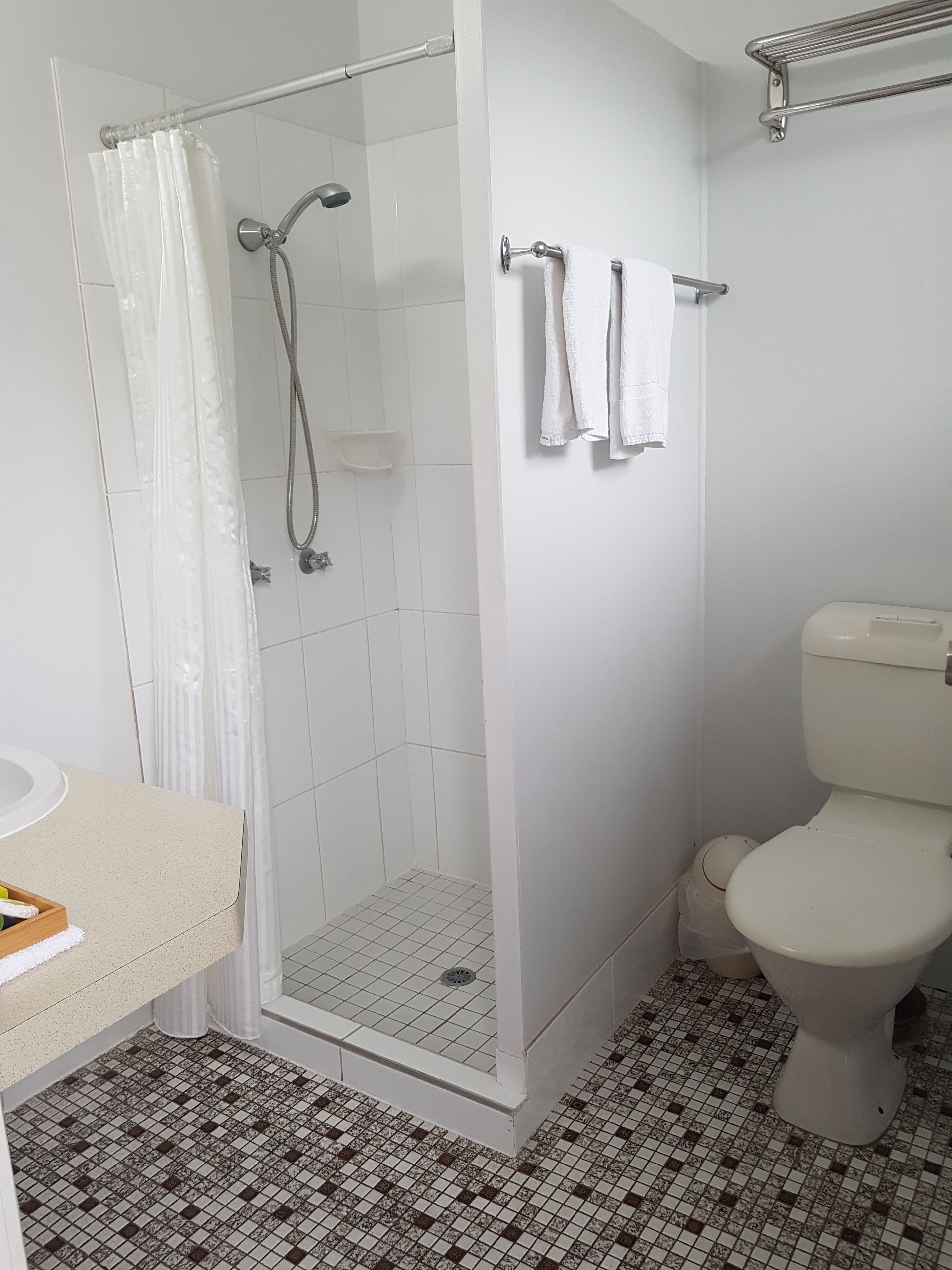 A bathroom with a shower, toilet, and sink.