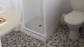 A bathroom with a shower, toilet, and sink.