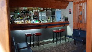Uma área de bar com balcão, banquetes e assentos.
