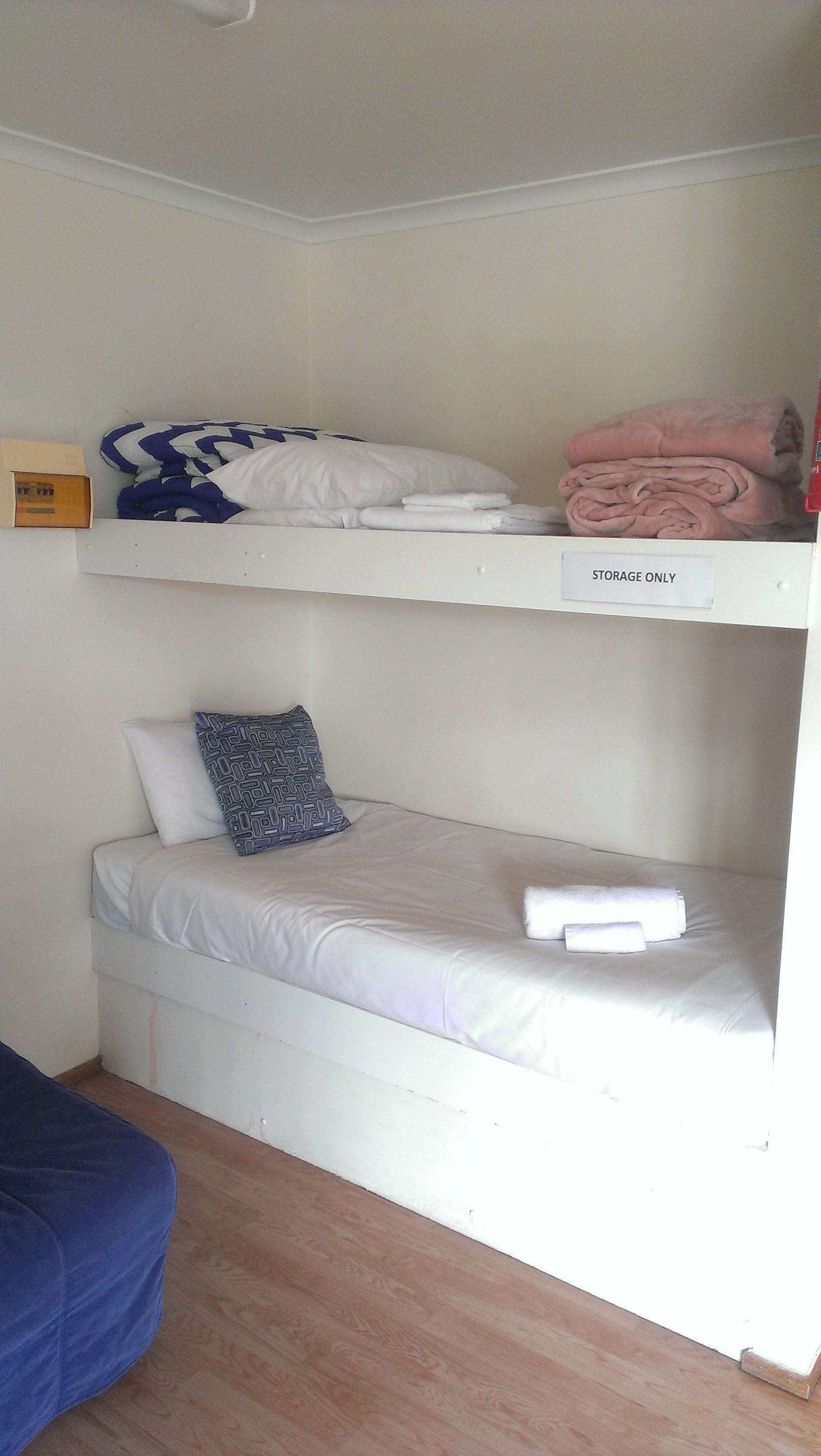 Una cama litera con un compartimento de almacenamiento etiquetado como 'SOLO ALMACENAJE'.