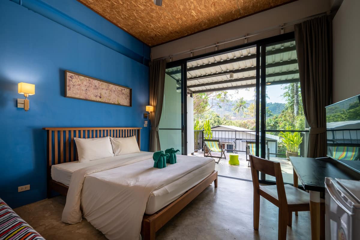 Una habitación de hotel con una cama grande, un escritorio y vistas a zonas verdes.