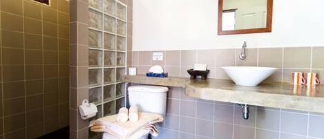 A bathroom with a toilet, sink, and mirror.
