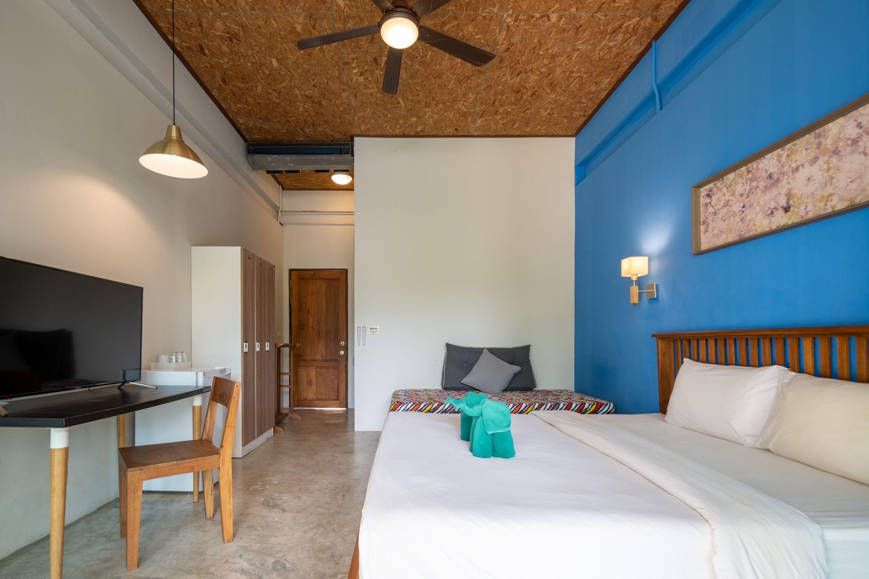 Un dormitorio con cama, escritorio y silla.