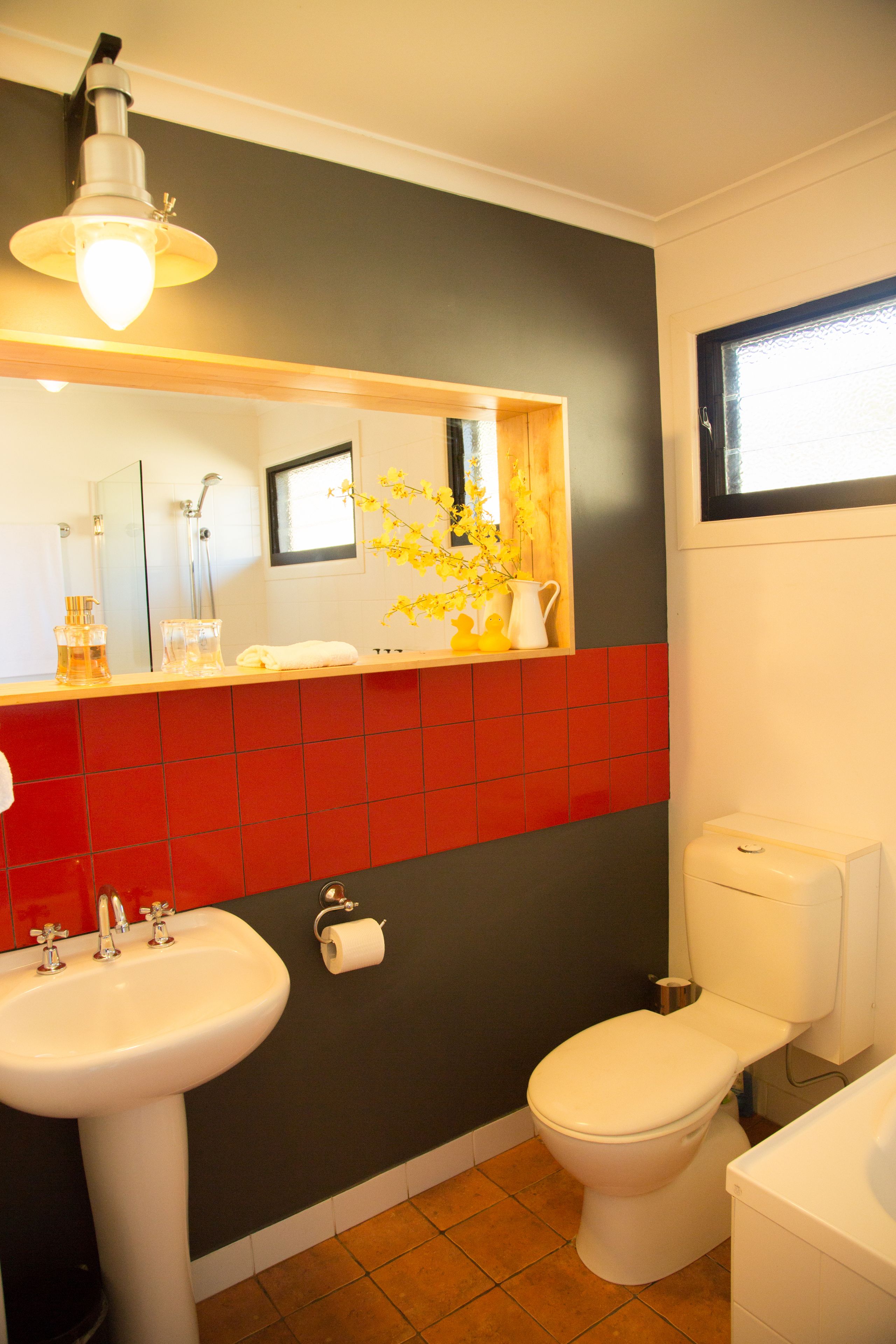 Une salle de bain avec un lavabo, des toilettes et un miroir.