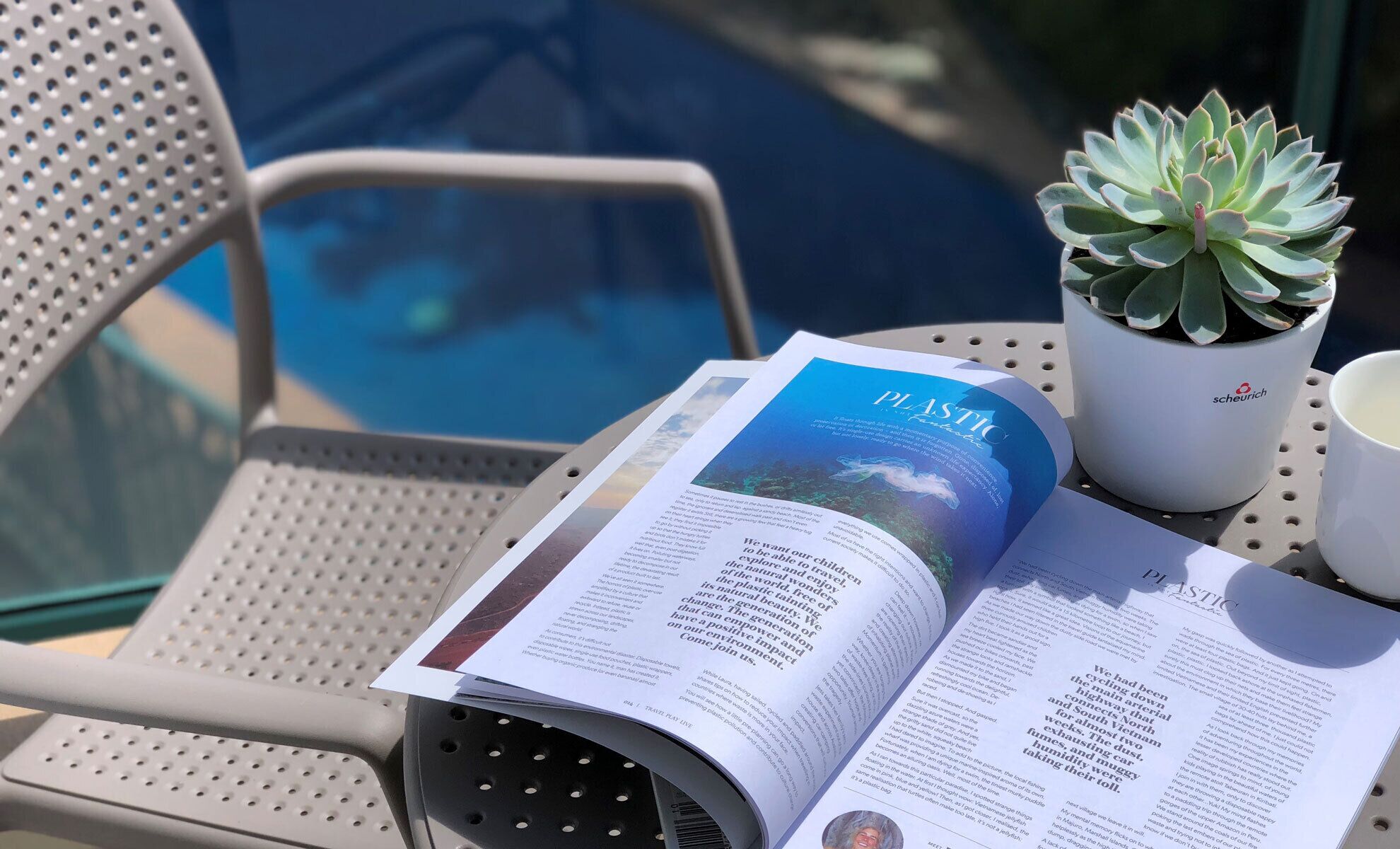 Una revista abierta sobre una silla metálica junto a una piscina.