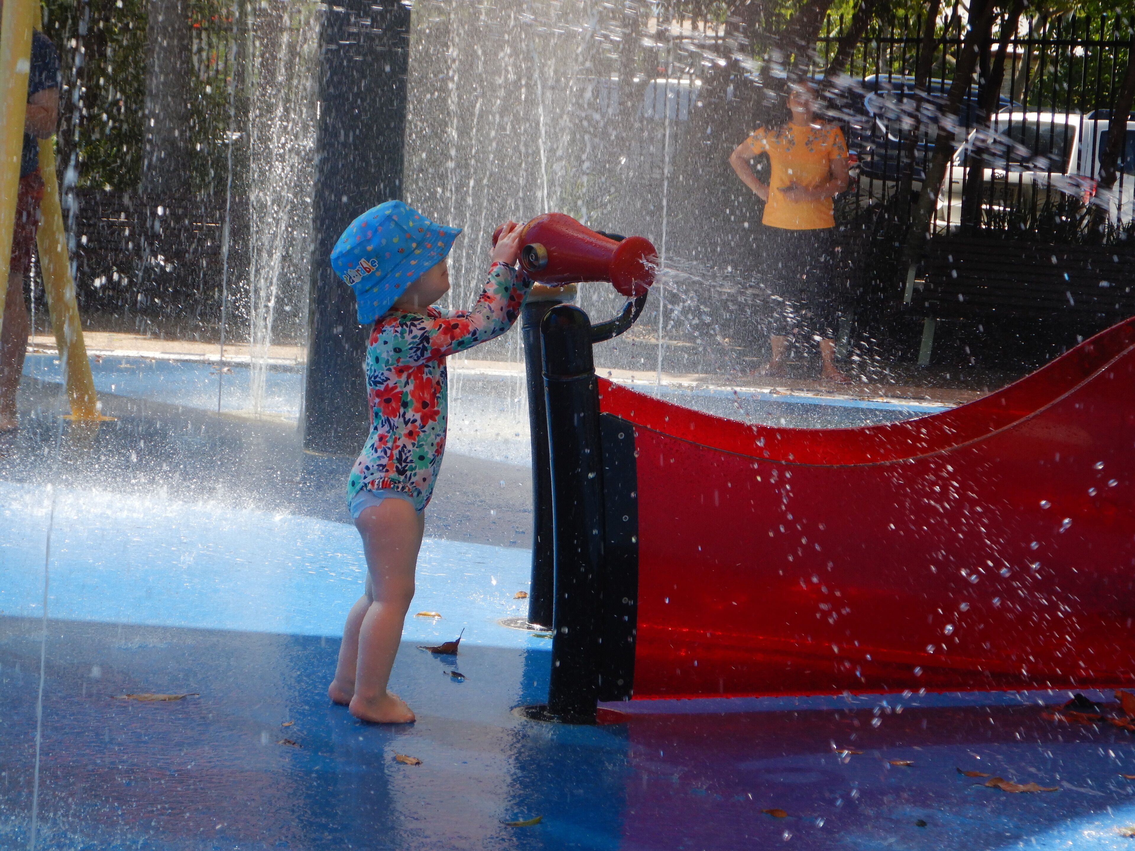 A child playing with water at a water park.
