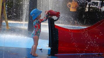 A child playing with water at a water park.