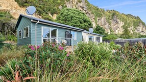 A house with satellite dishes, a porch, and a view of a cliff. - Punakaiki Beachfront Motels (Punakaiki)