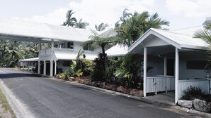 A two-story building with a covered porch and a sign indicating a restaurant. - Tully Motel (Tully)