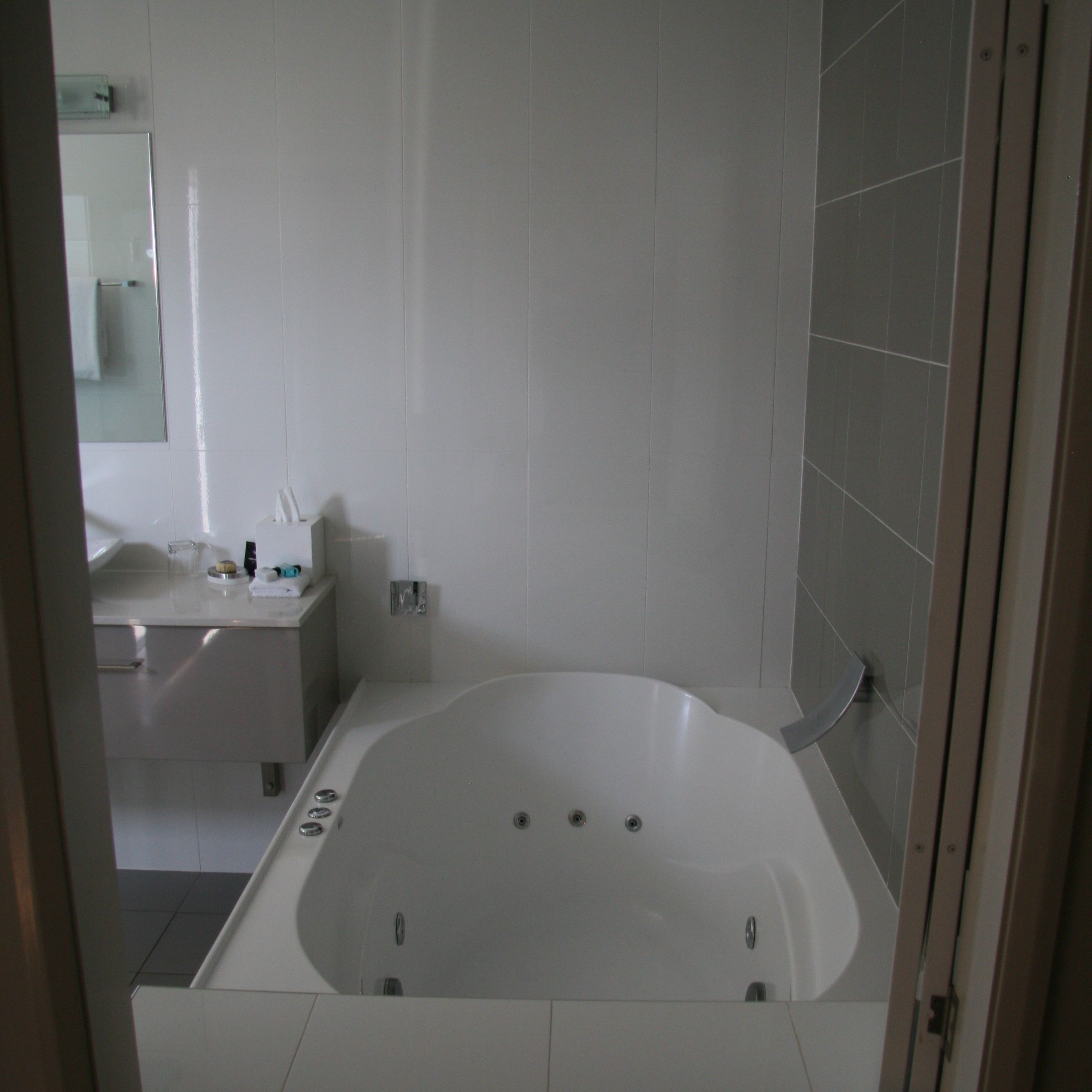 A modern bathroom with a freestanding bathtub, a vanity with a mirror, and a toilet.