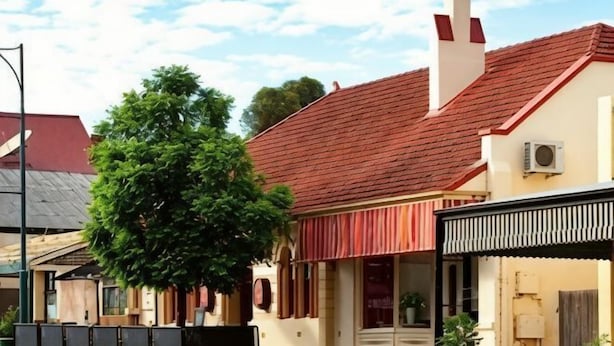 A building with a red-tiled roof, a chimney, and a tree in front. - Lambert Estate Retreat (Angaston)