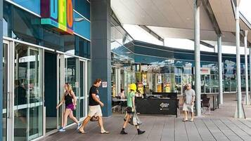 A modern building with a glass facade and a colorful sign.
