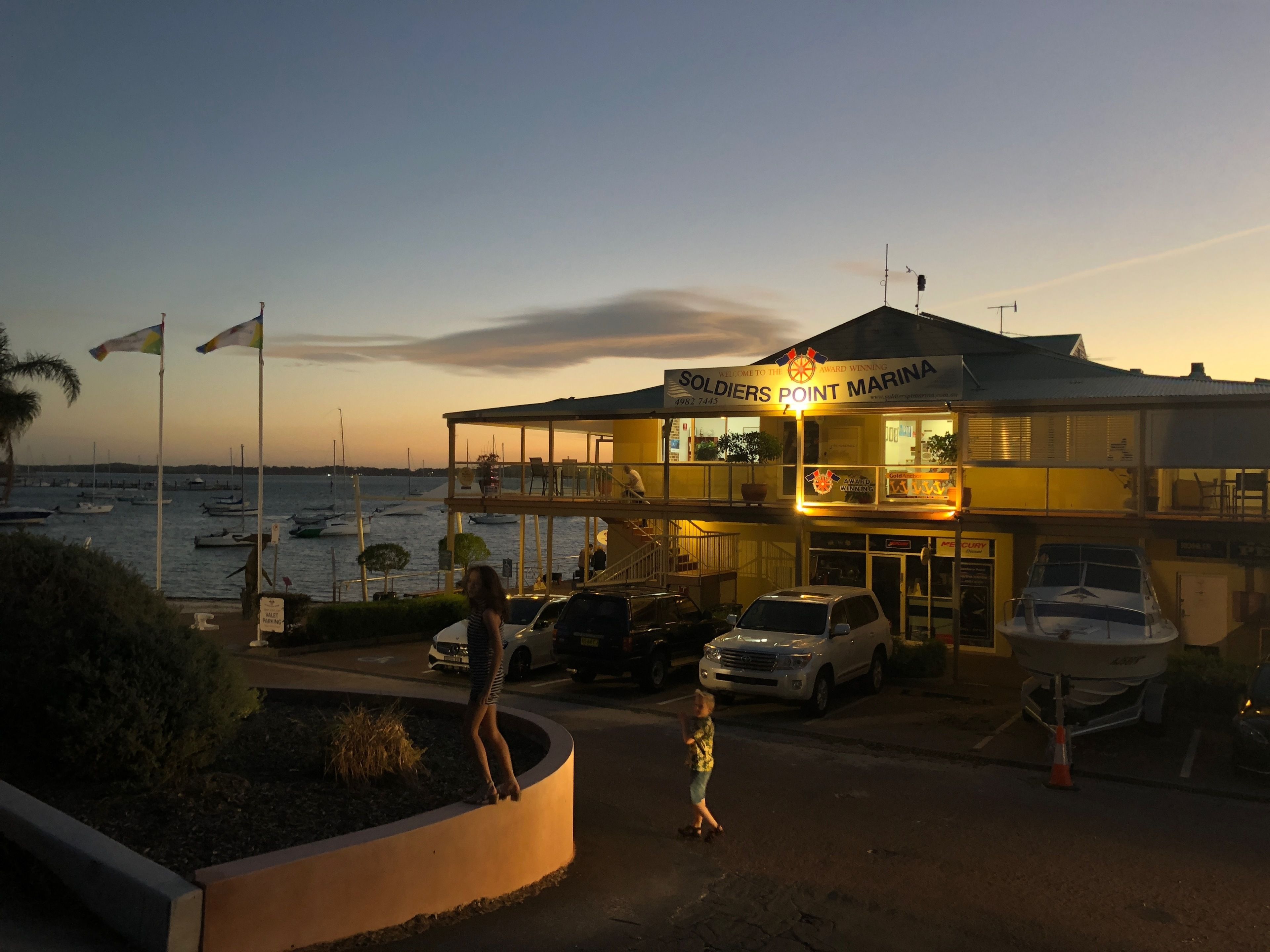 A waterfront building named "Soldiers Point Marina" with a sign indicating it is an award-winning establishment.