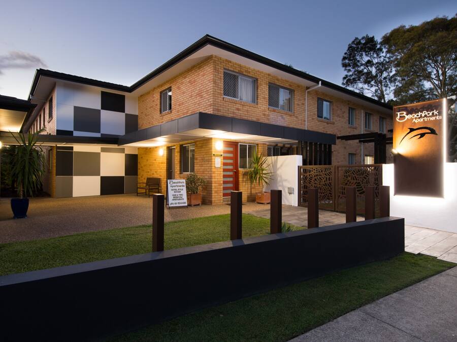 A modern two-story building with a sign for Beachpark Apartments.