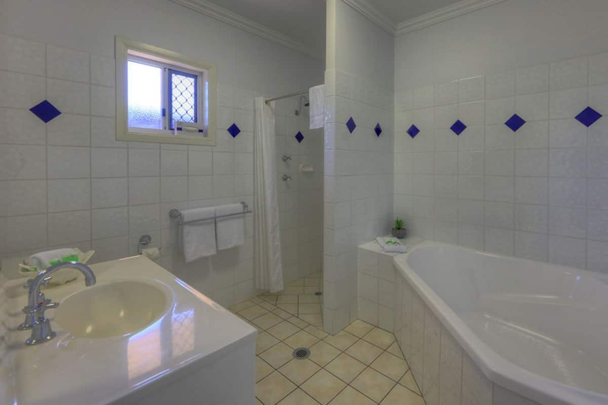 Un baño con lavabo, bañera y ducha.