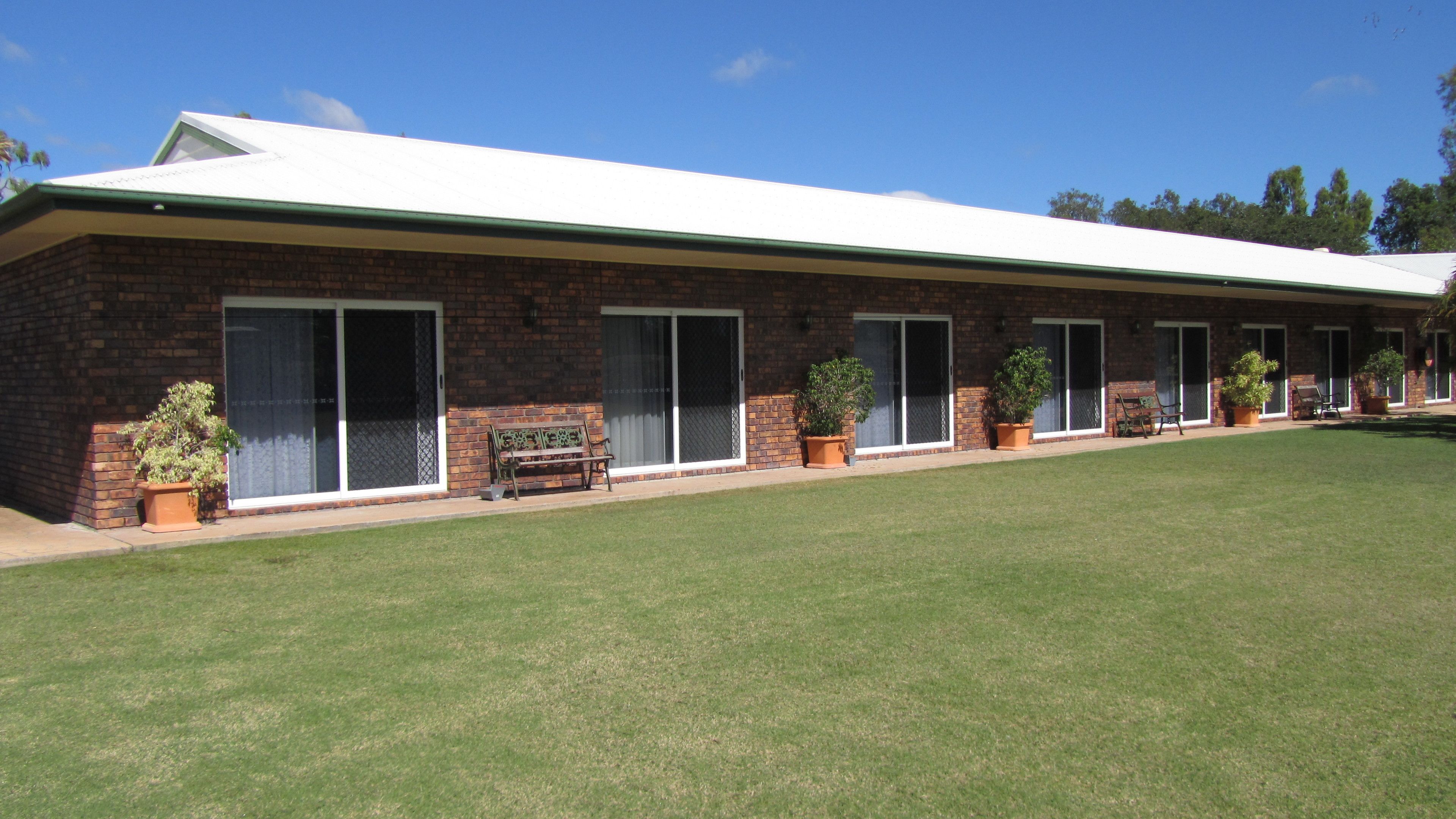 A long, single-story building with a flat roof and large sliding glass doors.