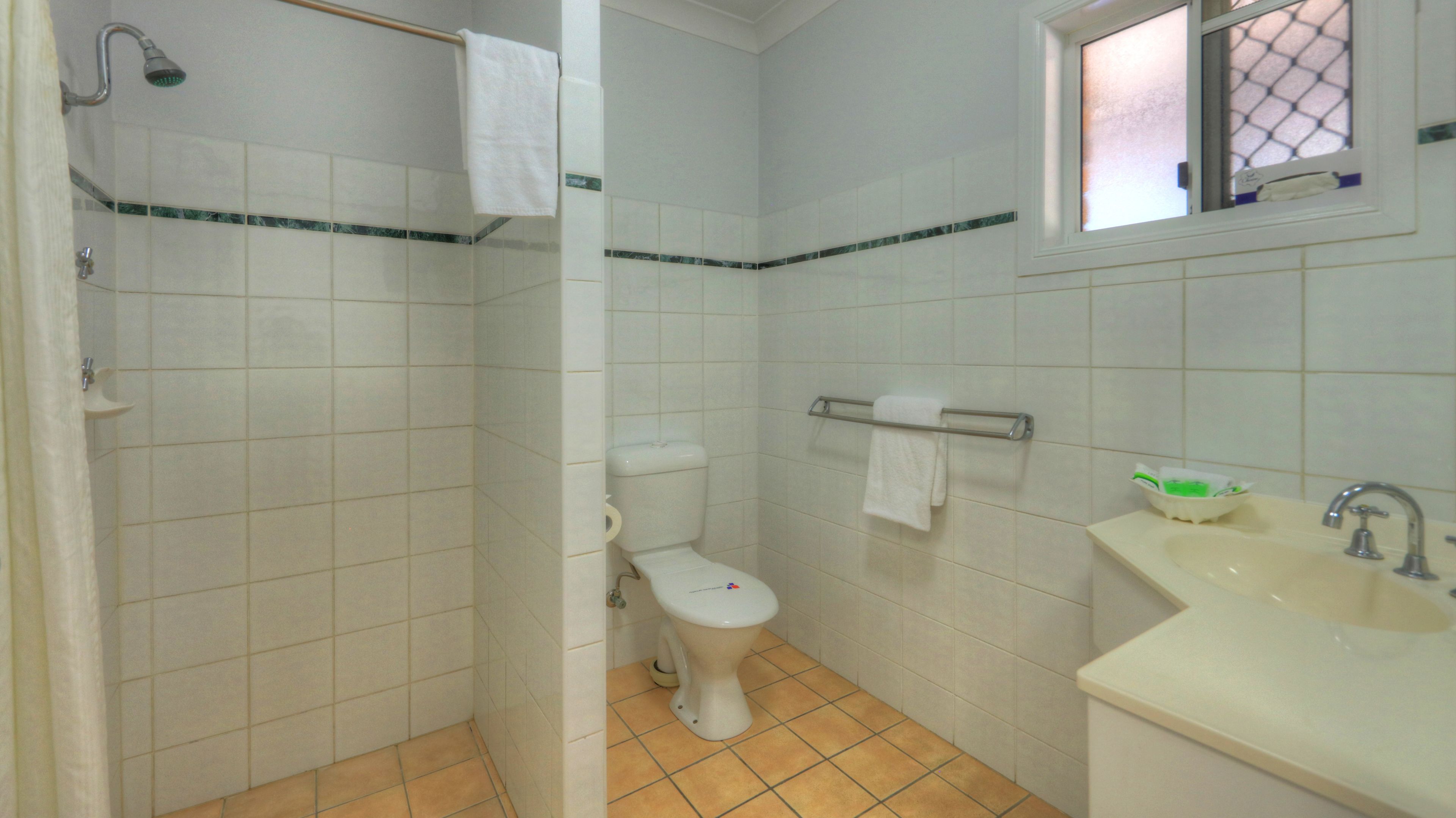 Un baño con ducha, inodoro y lavamanos.