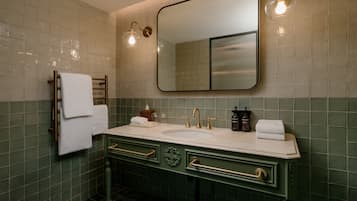 A bathroom with a double sink, two towel racks, a mirror, and two wall-mounted lights.