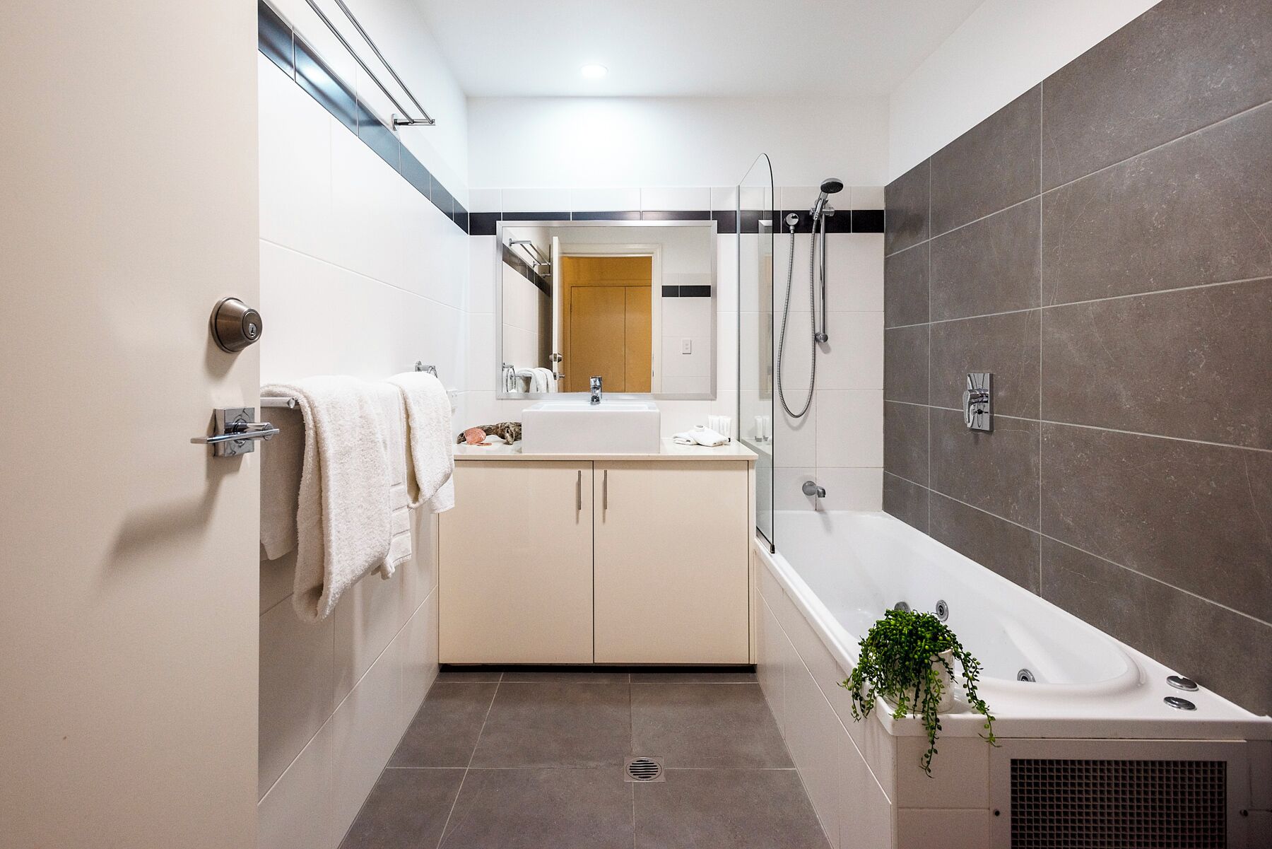 A modern bathroom with a bathtub, shower, and sink.
