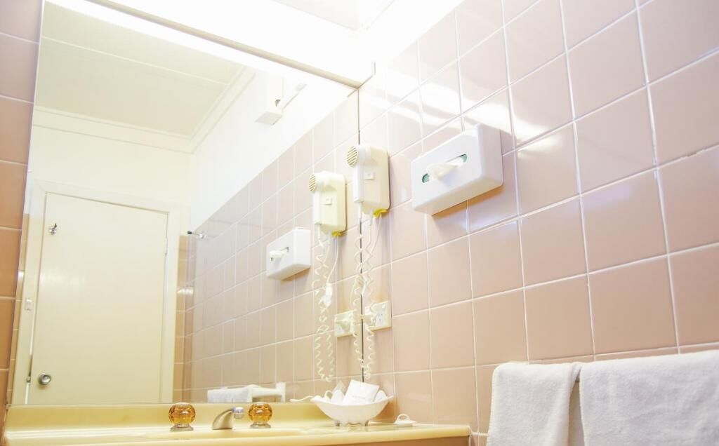 Une salle de bain avec un miroir, un lavabo et un porte-serviettes.