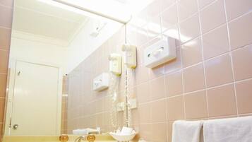 Une salle de bain avec un miroir, un lavabo et un porte-serviettes.