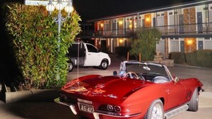 Un motel con letreros de neón que indican 'Motel Olympia' y 'Entrada'