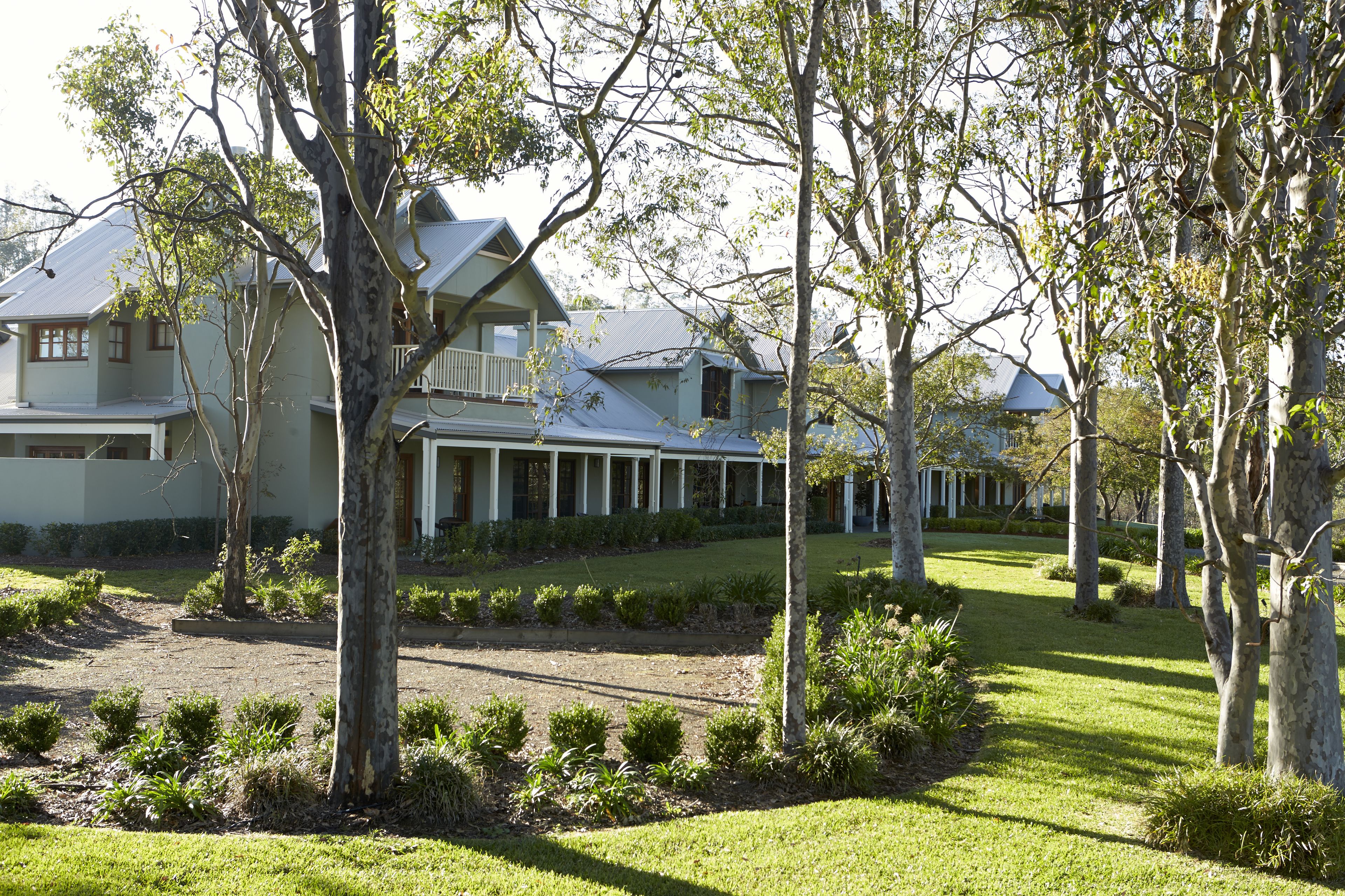 A large, light-colored house with a covered porch and multiple windows.