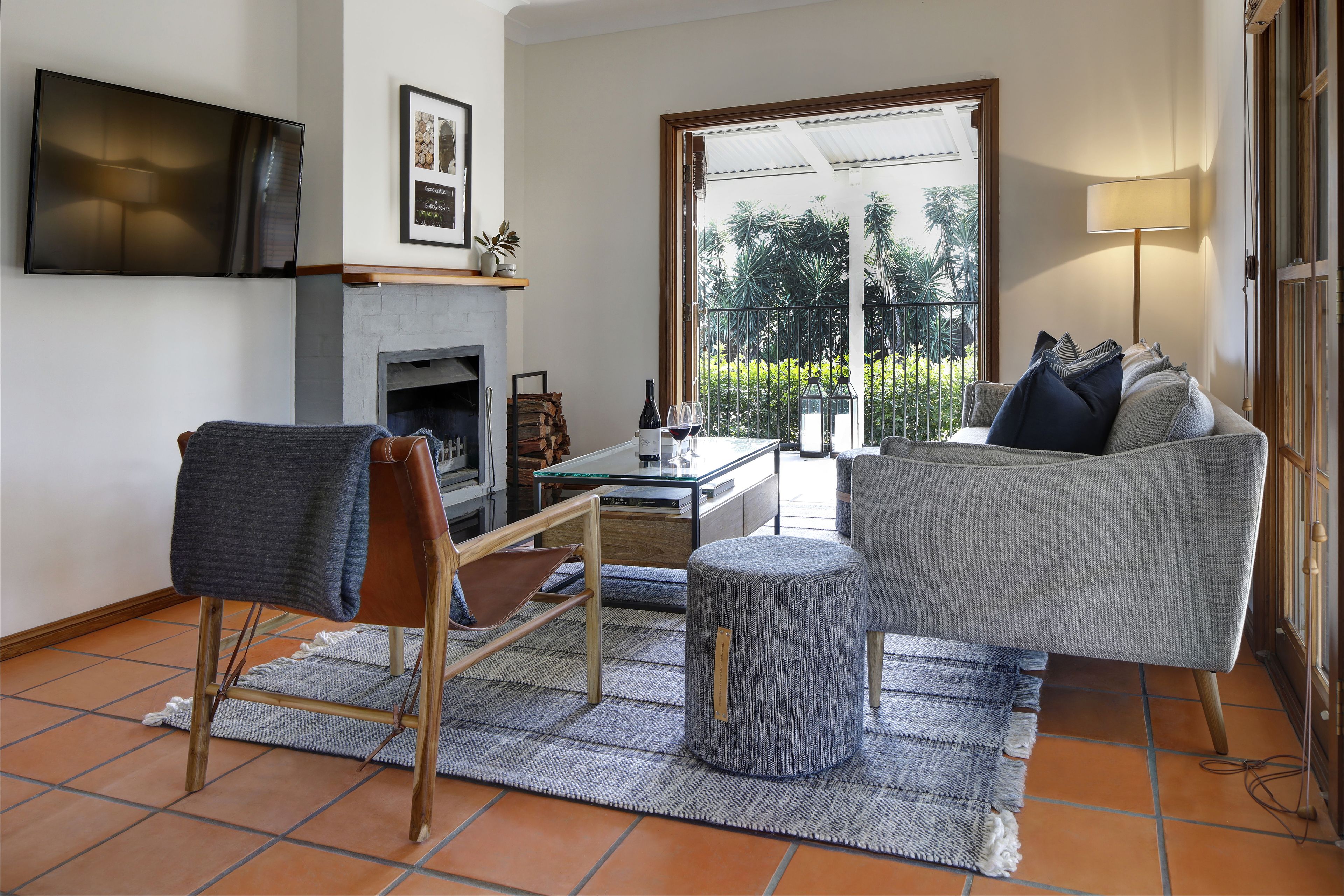 A living room with a fireplace, a sofa, a coffee table, and a television mounted on the wall.
