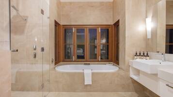 A modern bathroom with a glass-enclosed shower, a freestanding bathtub, and a vanity with a mirror.