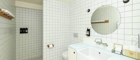 A modern bathroom with white tiled walls, a large bathtub, a round mirror, and a shower area.
