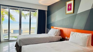 A hotel room with two beds, a large window with a view of the beach, and a framed picture on the wall. - Grand Elty Krakatoa (Kalianda)
