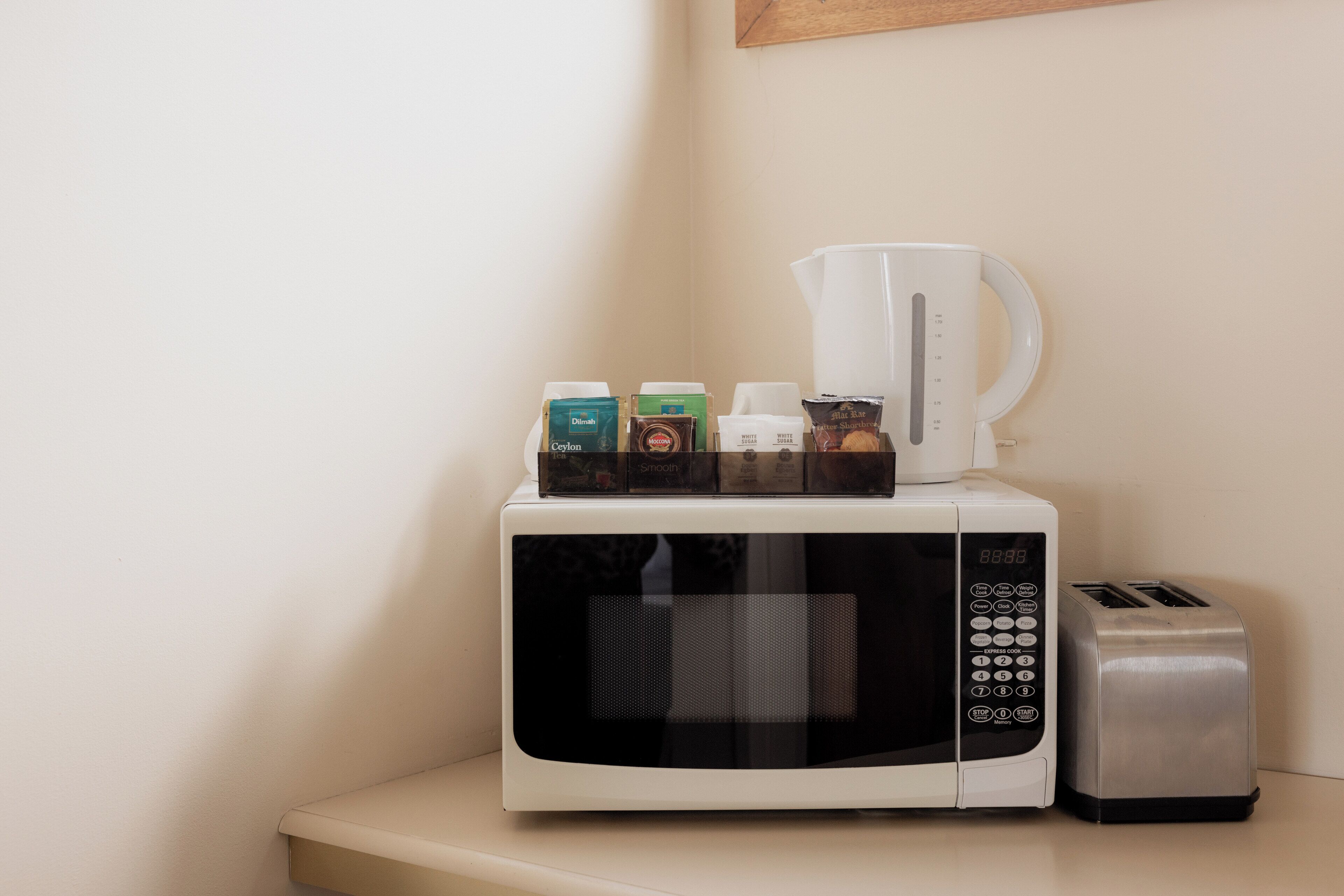A microwave with a coffee maker and a toaster on a countertop.