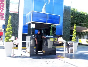 A man standing in front of a blue building with a sign that reads "PROMOTION Single Room After 11:00".