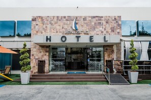 A hotel entrance with a stone facade, a logo above the name, and a sign for 'Velario Hotel'. - Hotel Velario (Tijuana)
