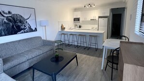 A modern living room with a grey sofa, a coffee table, and a ceiling fan.