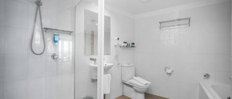 A modern bathroom with a glass shower enclosure, a toilet, a sink, and a bathtub.