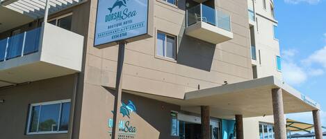 A multi-story building with a sign for DorsalSea Boutique Hotel and restaurant-bar-coffee.