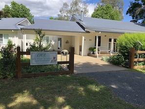 A two-story building with a signboard for 'G&K by the River Luxury Accommodation' and a wooden gate. - G.g's By The River (Eurobin)