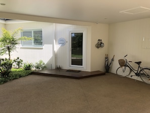 A clean, modern entrance with a white door, a small porch area, and a bicycle parked inside. - G.g's By The River (Eurobin)