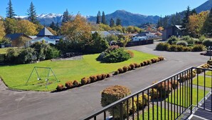 A residential area with houses, a playground, and a mountain backdrop. - Spa Lodge Motel (Hanmer Springs)