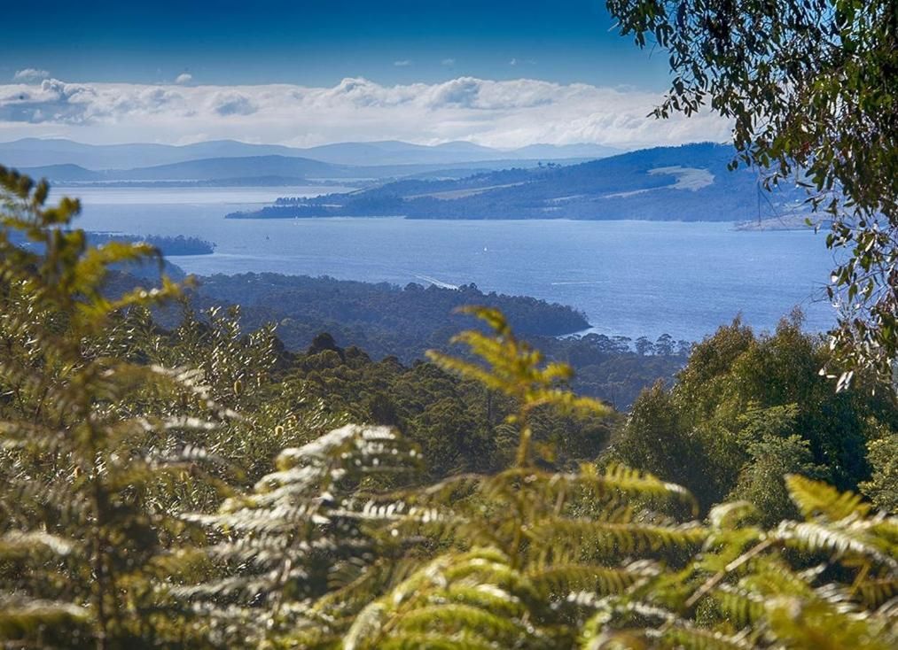 A coastal landscape with a view of the sea and distant mountains.