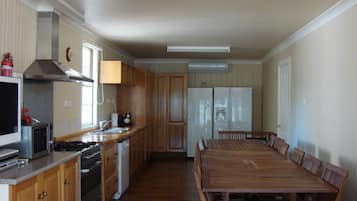 A kitchen with wooden cabinets, a stove, a microwave, and a refrigerator.
