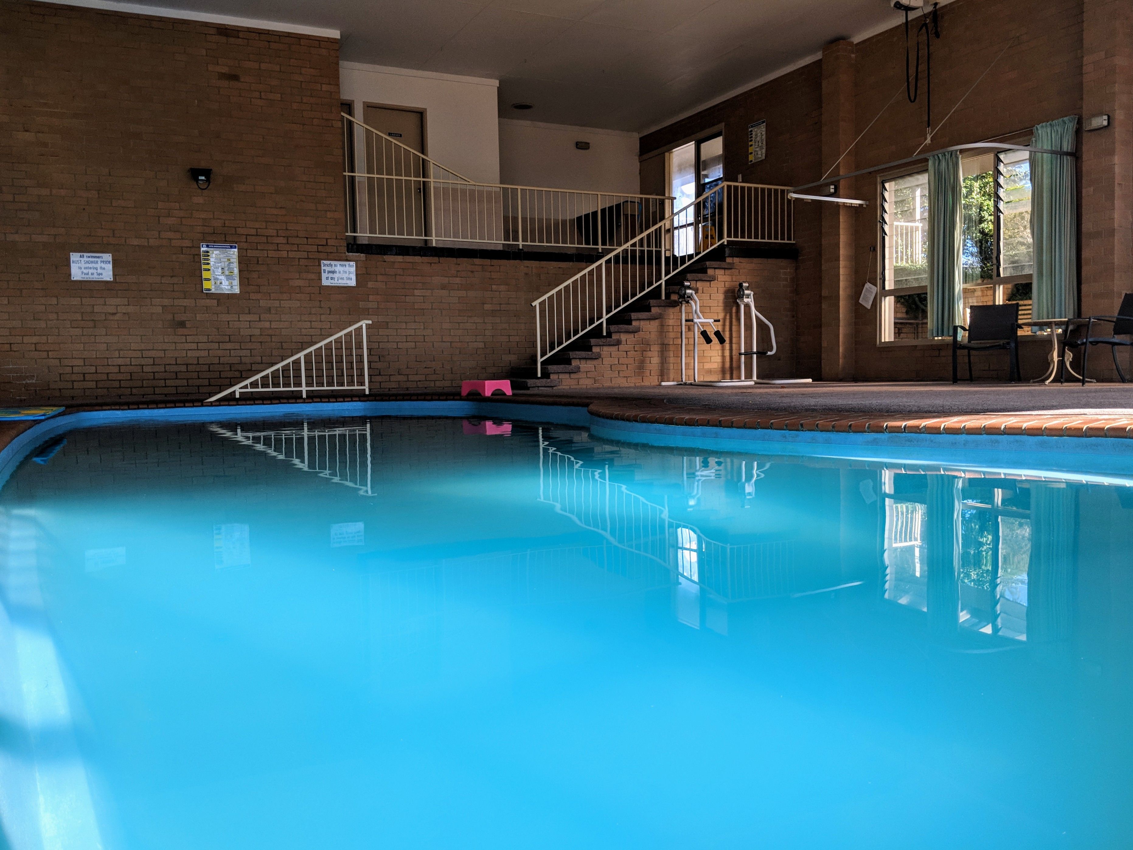 Uma piscina interior com uma escadaria que dá para um segundo nível.